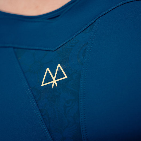 Blue sports bra with a gold logo on a close-up view