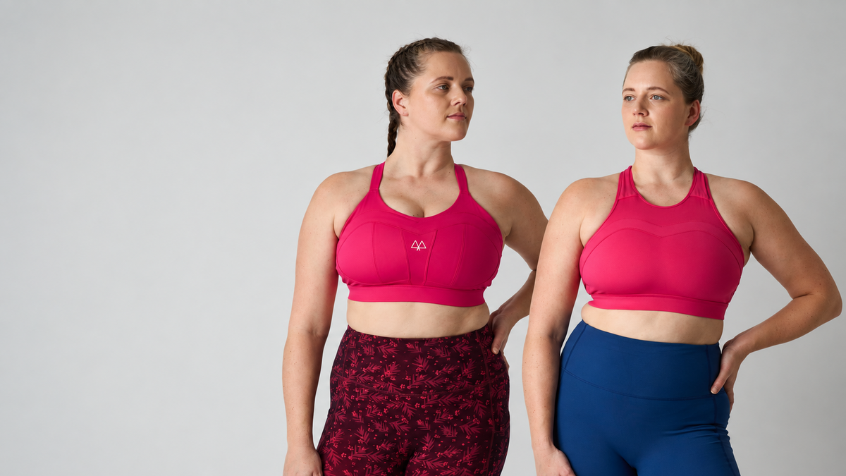 Two women modeling athletic sports bras and leggings sets against a light gray studio background. The woman on the left wears a bright pink sports bra with dark red patterned leggings, and the woman on the right wears a matching bright pink sports bra with solid blue leggings.