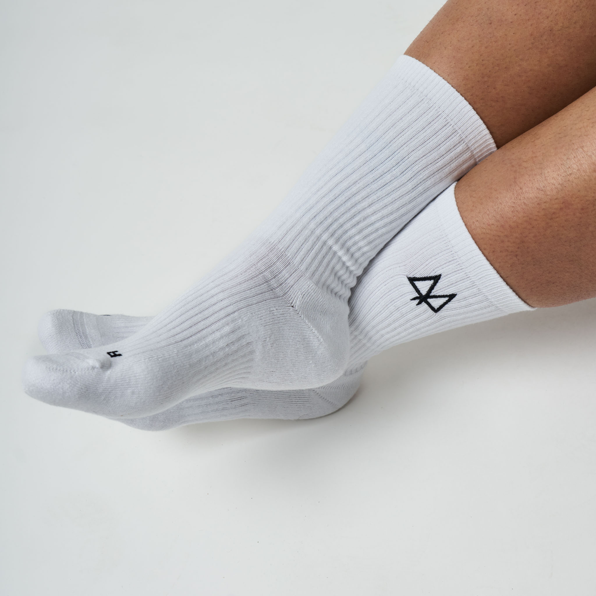 White socks with a black logo on a light gray background