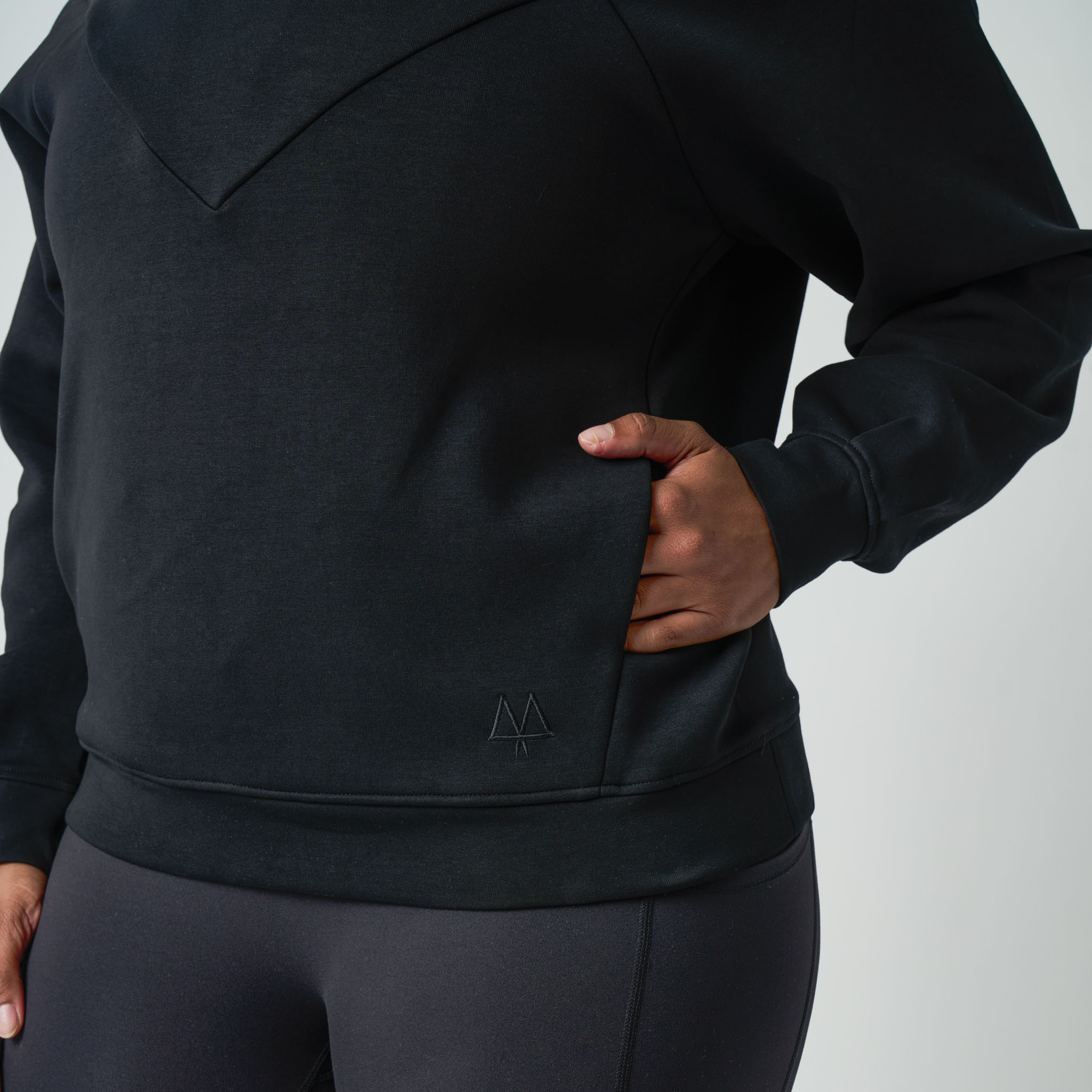 Person wearing a black hoodie with a MAAREE logo on a light gray background